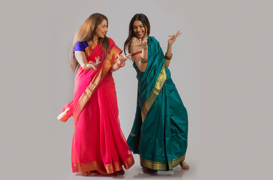 young women dancing in saree	