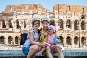 Young Family Sitting In Front Of Colosseum