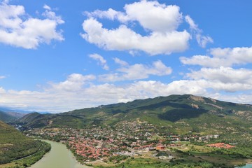 Fototapeta na wymiar Aerial panoramic view of Mtskheta village, near Tbilisi, where the Aragvi river flows into the Kura river. View from the Jvary monastery hill. The Mtskheta village is part of the UNESCO heritage site.