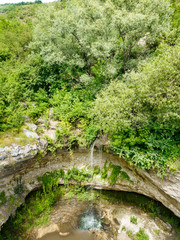 Fototapeta na wymiar Air view over smalll waterfall in the green forest.