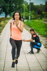 Female Exercising by the River with Personal Fitness Trainer