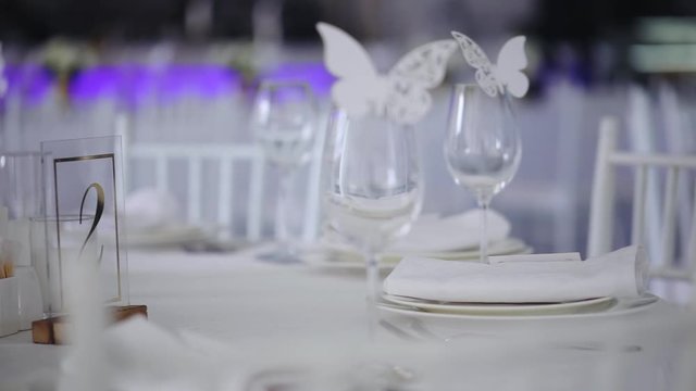 fashionable wedding table decoration with white flower bouquets decorative butterflies and number sign slow motion close