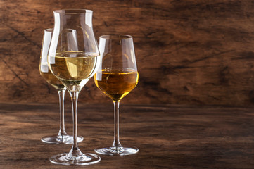 White wine set. Wine tasting, the most popular varieties of white wines in wine glasses on vintage wooden table in rustic style, selective focus