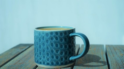 blue ceramic cup of coffee on wooden table