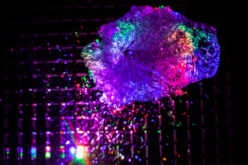 Abstract background of water splashes in multi-colored lighting. The texture of the water is...