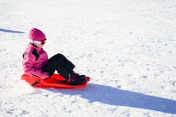 Little girl sledding at Sierra Nevada ski resort.