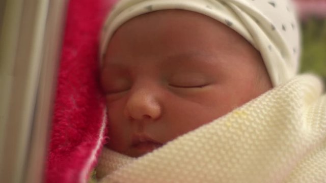 Closeup of newborn girl sleeping in maternity hospital