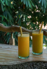 Zero waste concept with reuse bomboo straw, tropical delicious juice, Thai Bali seasonal, cool ice beverage for refreshing in summer on green nature bokeh background