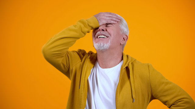 Upset aged man demonstrating face-palm gesture, failure sign, elderly loser