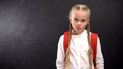 Unhappy pupil looking at camera, hating unloved school, problem child concept