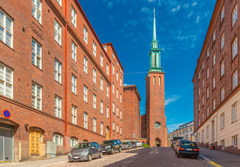 View of a street of Helsinki with the traditional red brick architecture and a Church (Kristuskyrkan), in the Finnish neo-gothic style, Finland