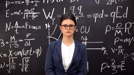 Serious woman physicist completing complex theorem and carried out calculations