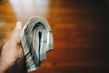 Indian man holding 500 rupee currency note bundle 