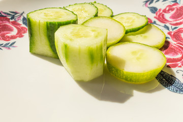 Fresh cucumber salad on white plate. Sliced fresh cucumbers.