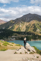 Girl admiring the view of Big Almaty Lake located in Tien Shan mountains in Kazakhstan