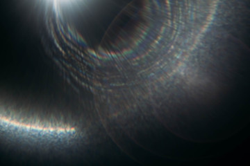 Blur rainbow lens flare on dark abstract background. Round spotlight rays and beams effect.