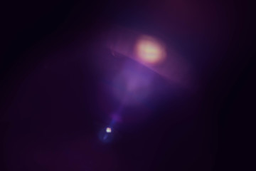 Blur lens flare. Dark purple abstract background. Defocused light dots reflection effect.
