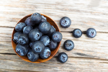 Blueberries in wooden bowls on wooden background