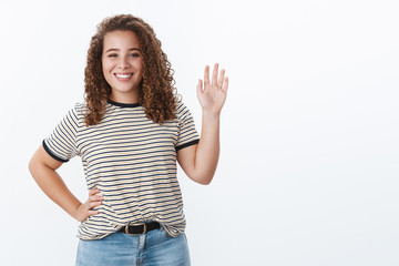 Hello my friend what up. Charming friendly happy young curly-haired overweight girl waving palm hi greeting gesture smiling positive meeting familiar person street welcoming guest, white background