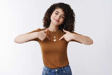 Me who you need. Self-assured attractive cheerful curly-haired glad girl bragging pointing herself...