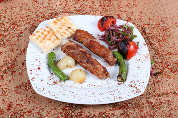 Turkish beef barbecue and fresh vegetables on a wooden table filled