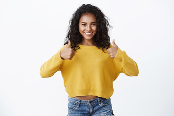 Girl giving her approval like idea. Happy attractive african american young woman in yellow autumn...