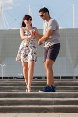 Young couple dancing Latino dance against urban landscape.