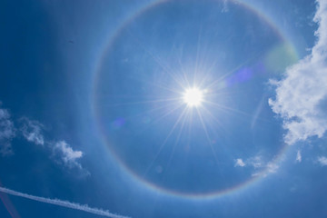  The silhouette sun halo at noon with the blue sky cloud, the beam, light and lens flare effect...
