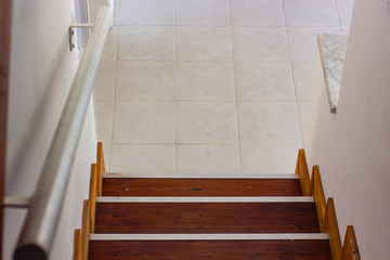 simple interior environment of top view wooden stairs and white tile floor, copy space 