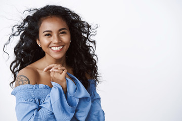 Elegance, wellbeing and women concept. Fashionable healthy and attractive african-american curly-haired woman with tattoos, wear blue blouse, smiling and laughing from happiness and joy