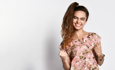 Obraz premium Happy cute curly girl in a light floral dress rejoices at what she received, found out, won