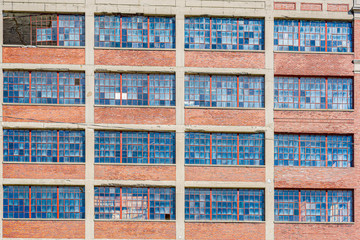 Abandoned factory's multiple floors of broken and rusted windows