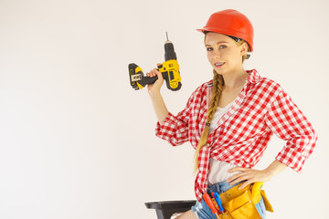 Woman wearing helmet using drill
