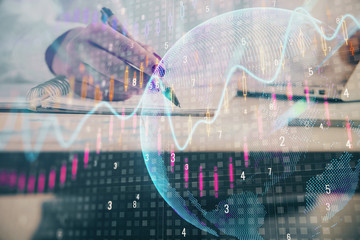 Double exposure of woman's hands making notes with forex graph hologram. Concept technical analysis.