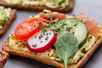 Sandwiches with cream cheese, vegetables and salami.