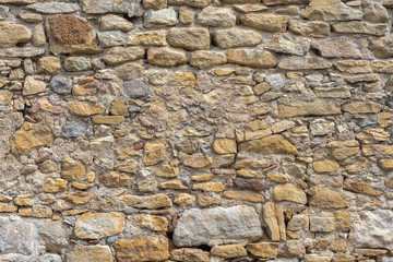 Aged yellow bricks and stones wall. Brick background