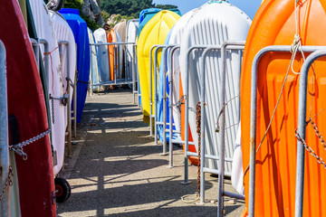 Rows of dinghies racked vertically in the port of Bugueles in Brittany, France, under a bright sunshine.