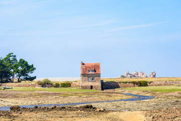 Tide mill of Bugueles in Brittany, France, at low tide on a sunny summer day.