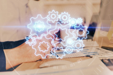 Double exposure of hands and notepad with business icons.