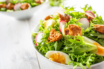 Salad with mixed ingredients pieces of chicken breast egg radish and olive oil