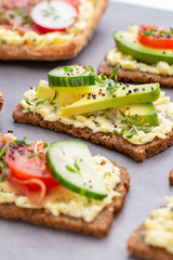 Sandwiches with cream cheese, vegetables and salami.