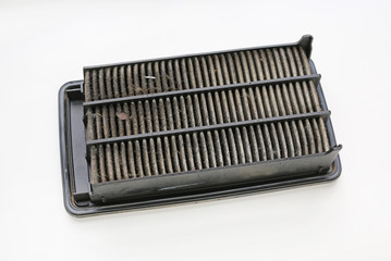 Dirty used car air conditioner filter on white background.