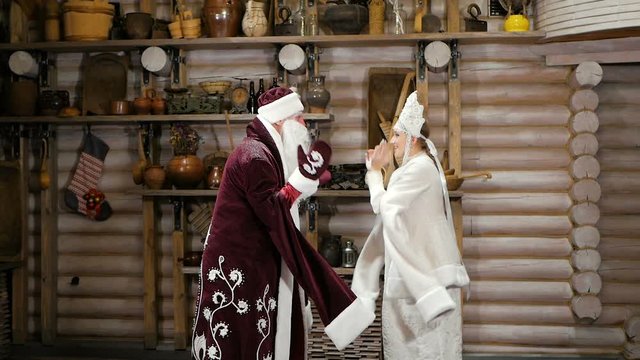 Santa Claus and snow maiden congratulate with New Year holidays