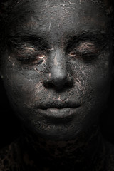 close-up woman face with black clay mask