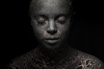 portrait of a woman with cracked black clay