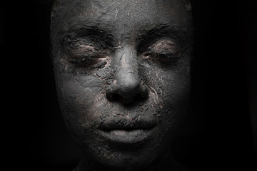 close up woman face with cracked clay skin cover