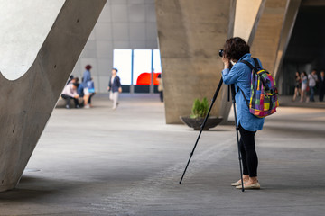 tourist takes photos with camera and tripod at a landmark of beautiful building, shallow depth of field