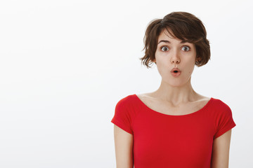 Wow something curious new. Impressed surprised tender silly woman short haircut folding lips say...