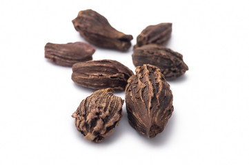 MACRO SHOT OF BLACK CARDAMOM ON WHITE BACKGROUND, GARAM MASALA ON ISOLATED BACKGROUND 