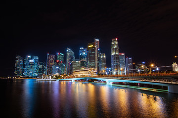 Naklejka na ściany i meble Business building and Merlion park and marina bay sand illuminated,landmark architecture at night in Singapore.